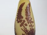 a yellow vase with a brown design on it