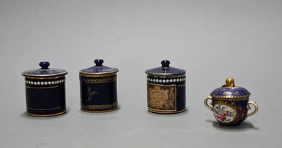 three small blue and gold containers are sitting on a white surface