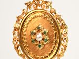 an image of a gold locke with a pearl in the center of it