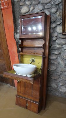 a sink and a cabinet in a room with a stone wall