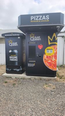 deux distributeurs automatiques proposant des pizzas, installés sur un parking