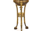 un socle richement décoré surmonté d'un bol en métal