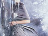 une femme en robe grise, debout devant une cascade