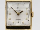 a close up of a gold watch with a brown leather strap