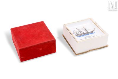 une petite boîte rouge sur laquelle est représenté un bateau