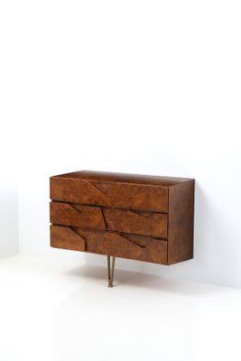 an image of a wooden chest of drawers in a white room