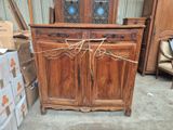 une grande armoire en bois entourée d'une pile de boîtes
