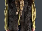 La femme porte un t-shirt vert et un gilet en fourrure marron.