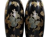 une paire de vases noirs ornés de motifs dorés et bleus