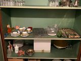 une armoire verte sur laquelle sont posés de nombreux plats et verres