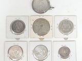 six different types of coins in a display case on a white surface