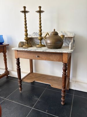 une petite table sur laquelle se trouvent deux bougies et un vase