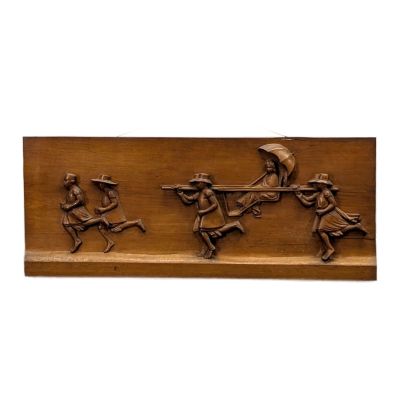 a close up of a wooden plaque with a man on a horse