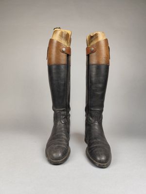 une paire de bottes en cuir marron et noir, avec des boucles de chaque côté