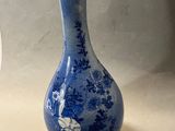 un vase bleu et blanc posé sur une table