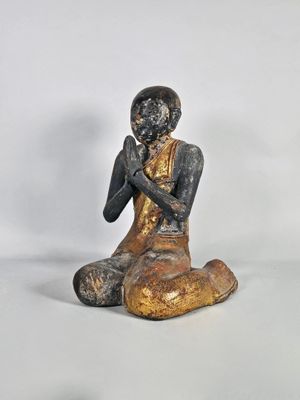 statue représentant un homme assis par terre, les mains jointes sur la poitrine