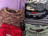 several sweaters are stacked on top of each other on a table