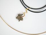 gold plated necklace with a leaf charm on a black leather cord