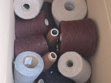 many spools of thread in a box on the floor