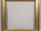 a close up of a gold picture frame on a white wall