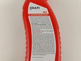 a close up of a bottle of red liquid on a white surface