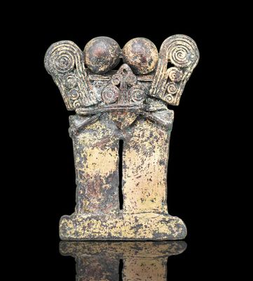 Pendentif représentant un chamane stylisé tenant deux tubes …