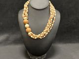a necklace with two strands of wood beads on a mannequin