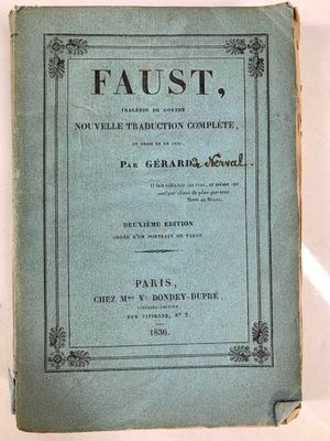 un vieux livre posé sur une table à côté d'une tasse de café