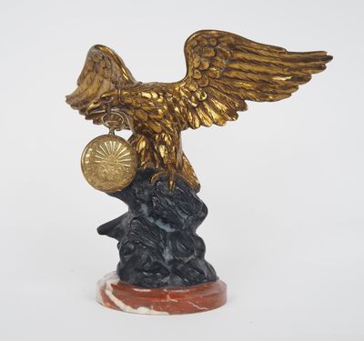 une statue représentant un aigle tenant une boule au sommet d'un rocher