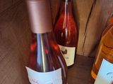 three bottles of wine sitting on a shelf next to each other