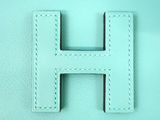 the letter h is made of leather and has a white stitching on it