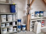 several buckets of paint on the shelves in the garage