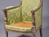 an old chair with a green upholstered back and gold trim