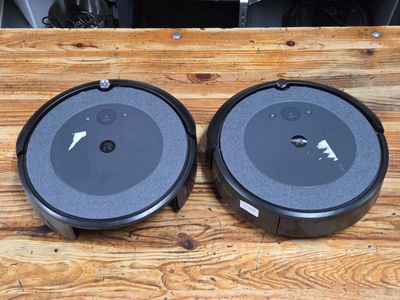 two black speakers sitting on top of a wooden table next to each other