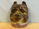 a ceramic dog head on a wooden table