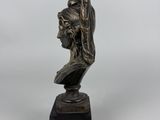 a bronze statue of a man holding a flag on top of a wooden base