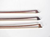 four different types of wooden knitting needles on a white surface