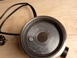 a metal object on a wooden table with a cord