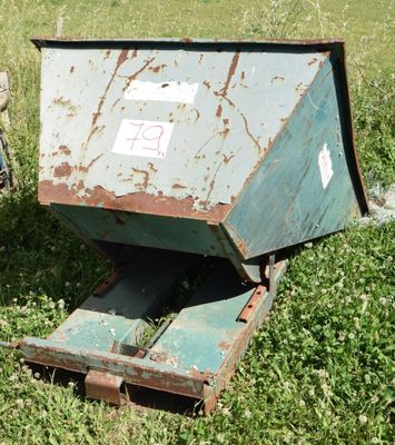 a man standing next to a dumpster in a field