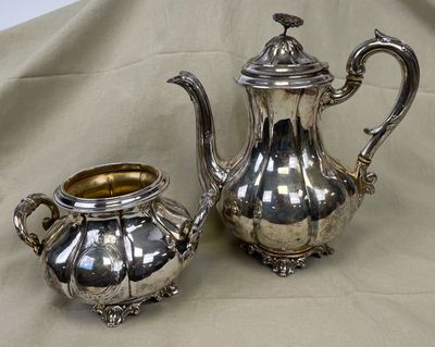 une théière en argent et une autre théière en argent posées sur une table