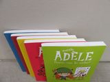 four children ' s books are lined up on a couch