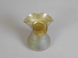 a small silver vase with a gold flower on it