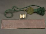 a belt with a metal buckle and a tassel on a table