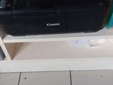 a printer sitting on top of a shelf in a room