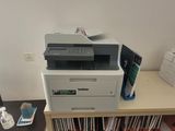 a printer sitting on top of a desk next to a computer monitor