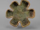 a close up of a green flower shaped bowl on a gray surface