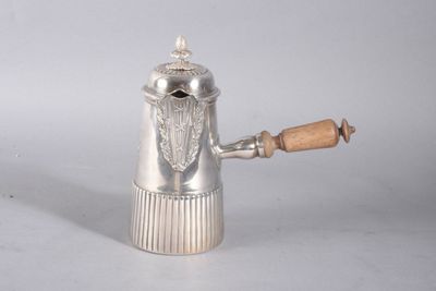 une théière en argent avec une anse en bois posée sur une table