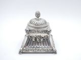 an antique silverplated sugar dish with a lid on a stand
