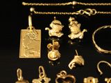 a close up of a collection of gold jewelry on a black surface