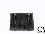 un sac à main en cuir noir avec une poignée dorée